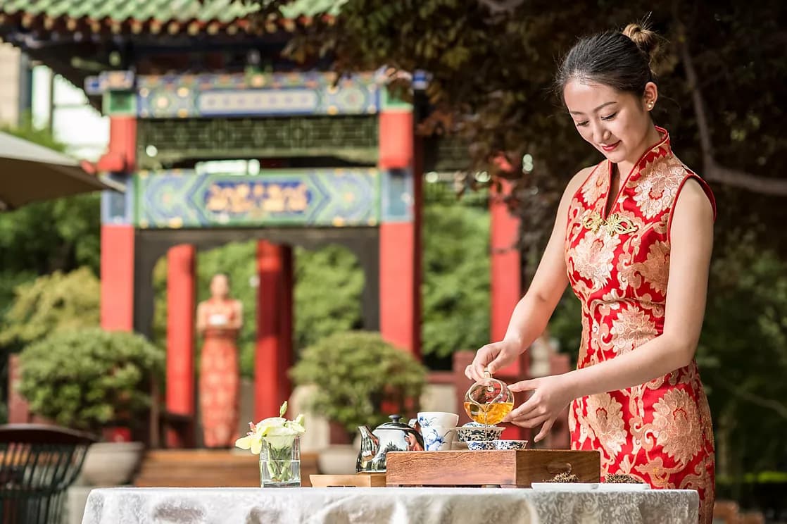 Woman preparing traditional tea at Sofitel Legend Peoples Grand Hotel Xian courtyard