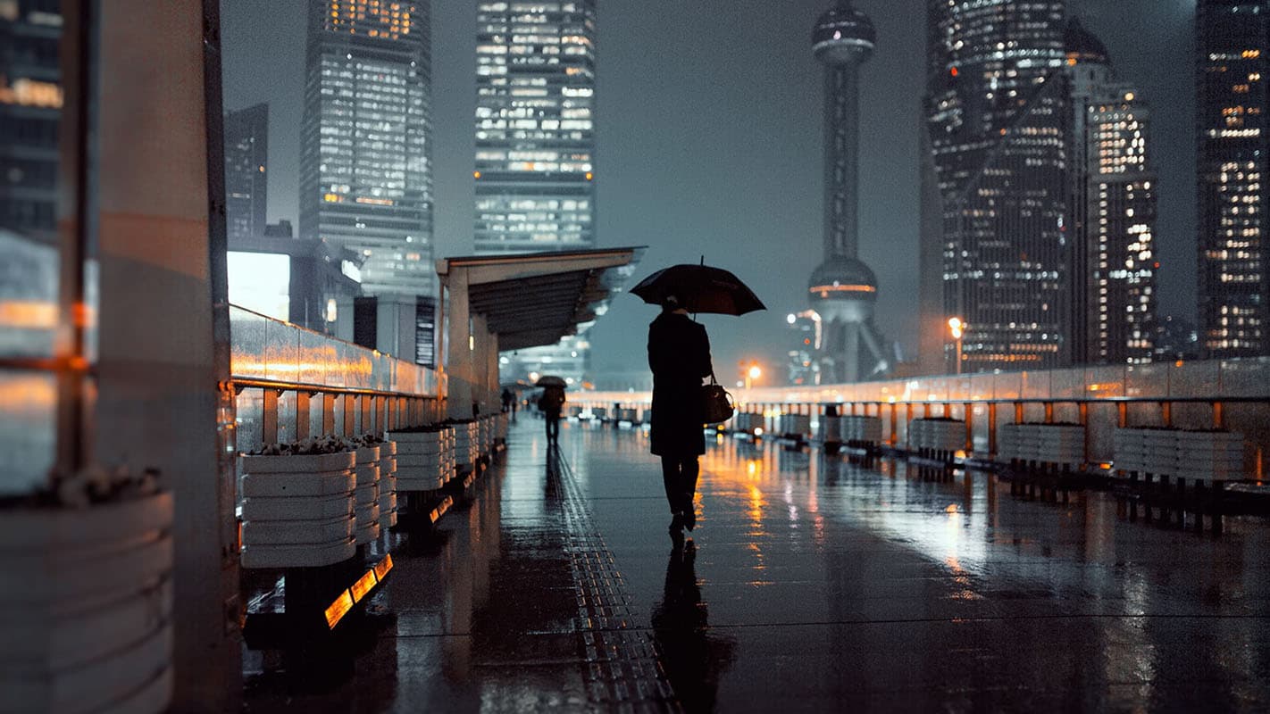 Night reflections along the Bund in Shanghai beneath rain and glowing skyscrapers